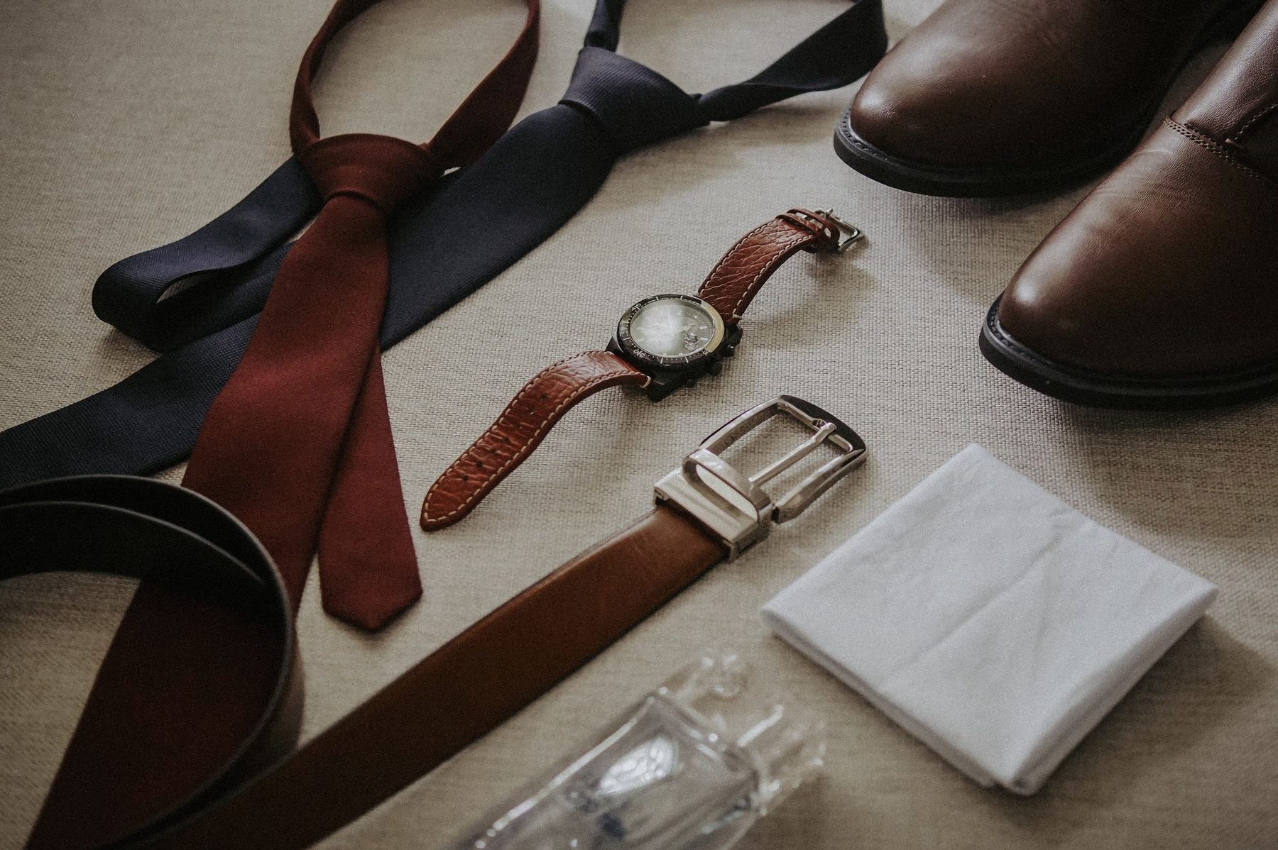 Formal shoes, ties, belt, braces and pocket square laid out together